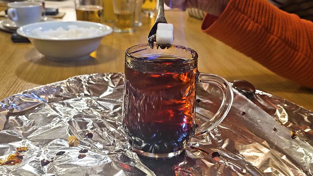Nahaufnahme des Krambambuli-Rituals: Zucker schmilzt in brennenden Schnaps