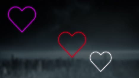 animación de corazones de neón rojo, rosa y blanco que parpadean sobre un fondo oscuro