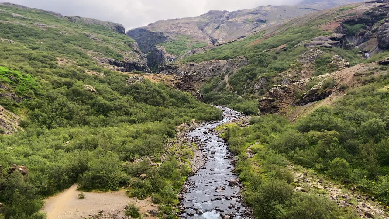 Piccolo fiume di montagna che scorre attraverso una valle rocciosa in Islanda in una giornata nebbiosa