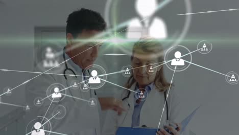 Animation-of-network-of-connections-with-icons-over-diverse-doctors