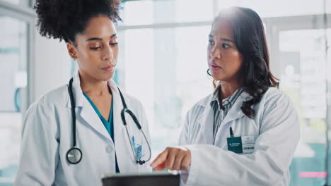 two female doctors discussing patient information on a tablet