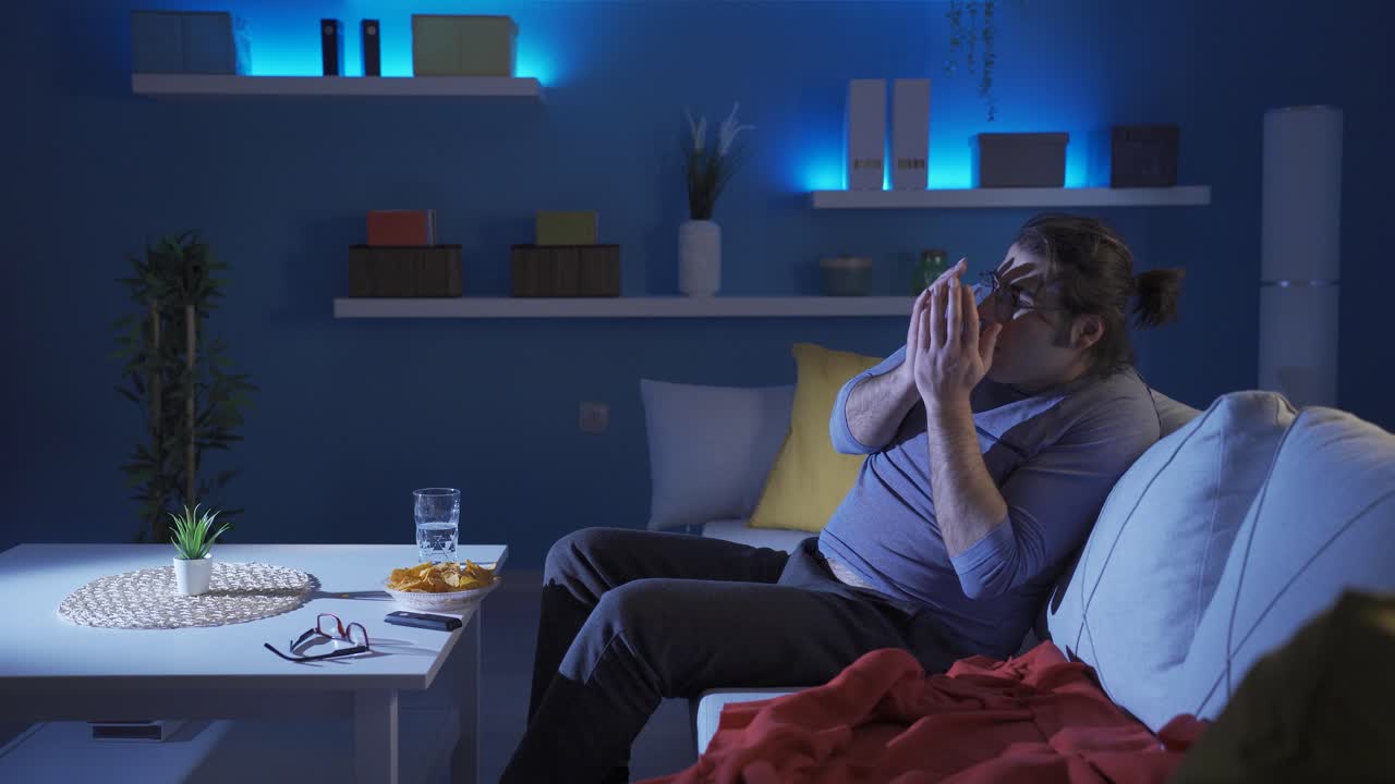 Homem engraçado está assustado enquanto assiste TV.