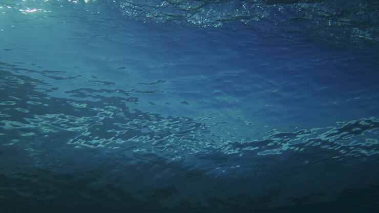 Affascinante retro di un'onda oceanica con panoramica subacquea mentre si infrange.