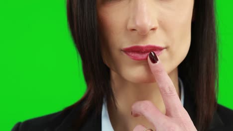 mujer de negocios poniendo el dedo en sus labios