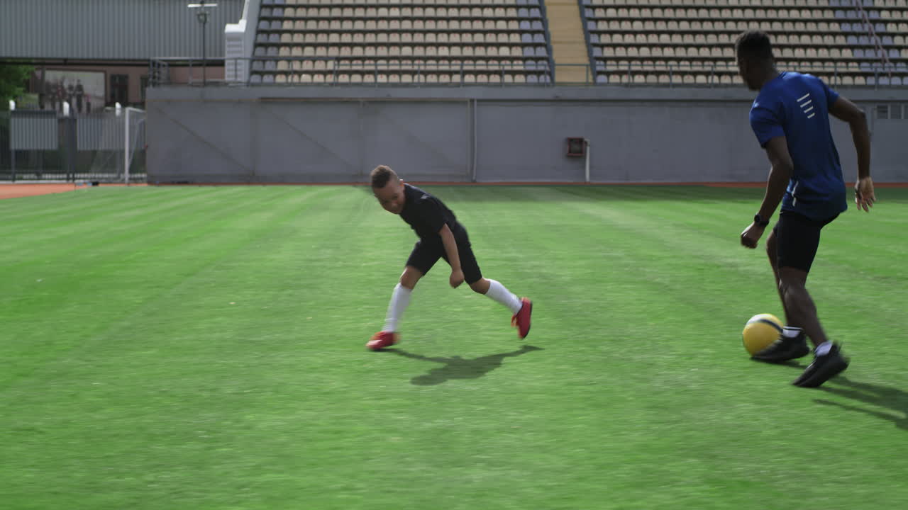 Father and son playing soccer in a stadium