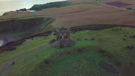 Aerial-footage-of-Stonehaven-War-Memorial-at-sunrise,-Aberdeenshire,-Scotland