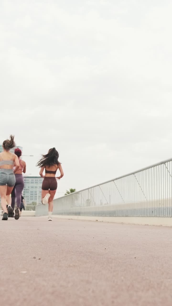 Four Women Running on a Bridge in the City
