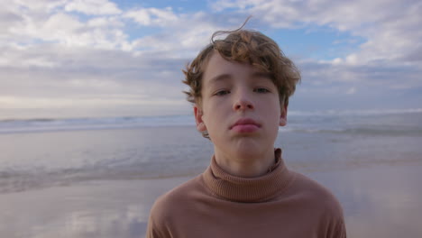 portret van een bedachtzame jongen op het strand