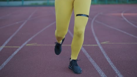 mujer corriendo en una pista al aire libre con ropa deportiva en un campo atlético