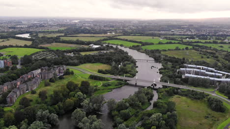 aerial, university on limerick campus, shannon river and cityscape in background on cloudy summer day, drone shot