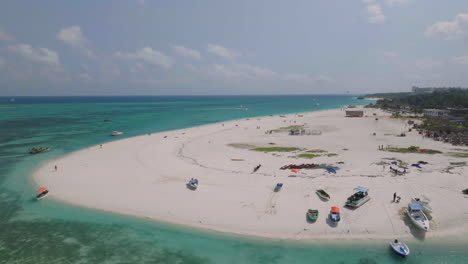 Vista-De-Drones-De-Una-Hermosa-Playa-De-Arena-Y-Un-Océano-Turquesa-Con-Barcos,-Gente-Y-Cielo-De-Nubes,-Zanzíbar,-Kendwa,-áfrica,-Filmada-A-30-Fps