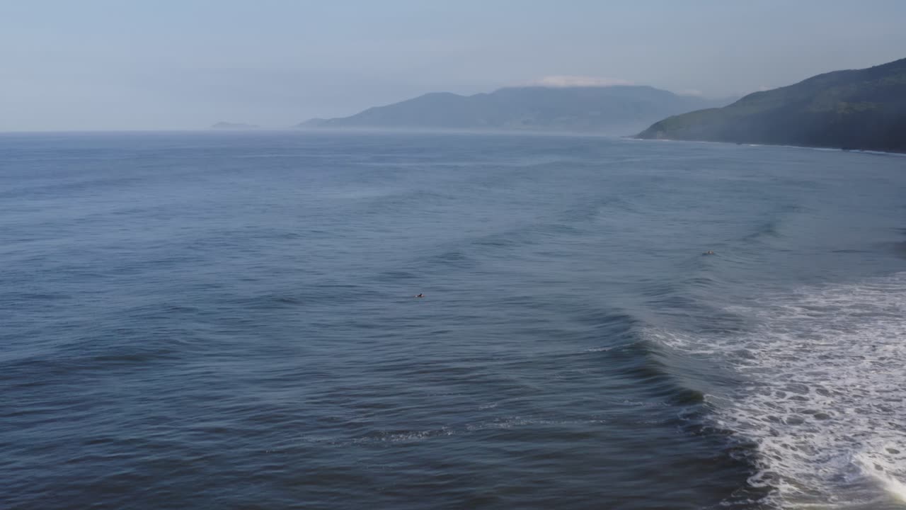 공중: 부서지는 파도 뒤의 서핑보드에서 휴식을 취하는 남성 서퍼들, 멕시코