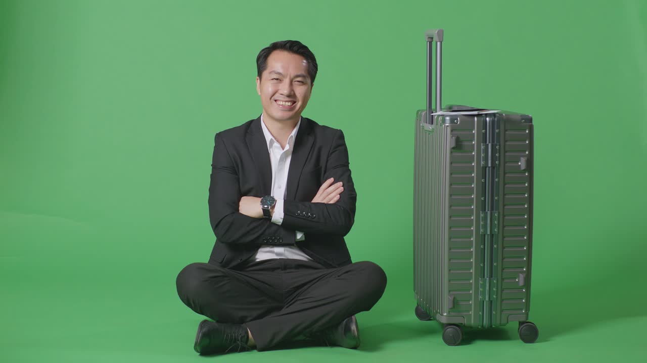 비즈니스맨이 녹색 스크린에 수과 함께 앉아 있습니다.