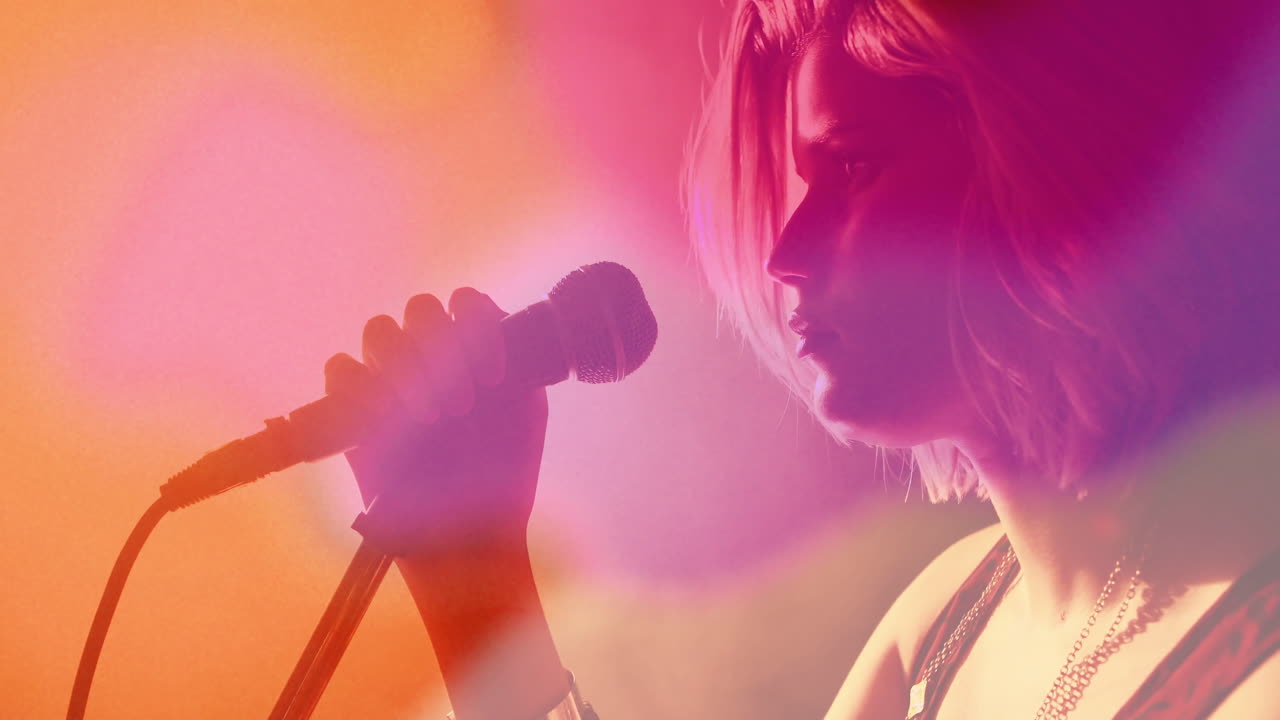 female singer gripping microphone, performing music under vibrant stage lights with animated haze