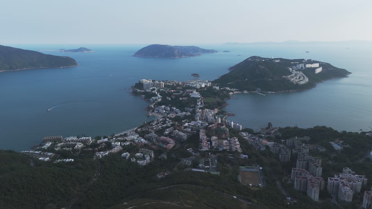 Vista aerea con drone di Repulse Bay, Hong Kong. Cattura una spiaggia di sabbia dorata, acque turchesi e lo skyline della città con le colline circostanti in un panoramico scenario costiero.