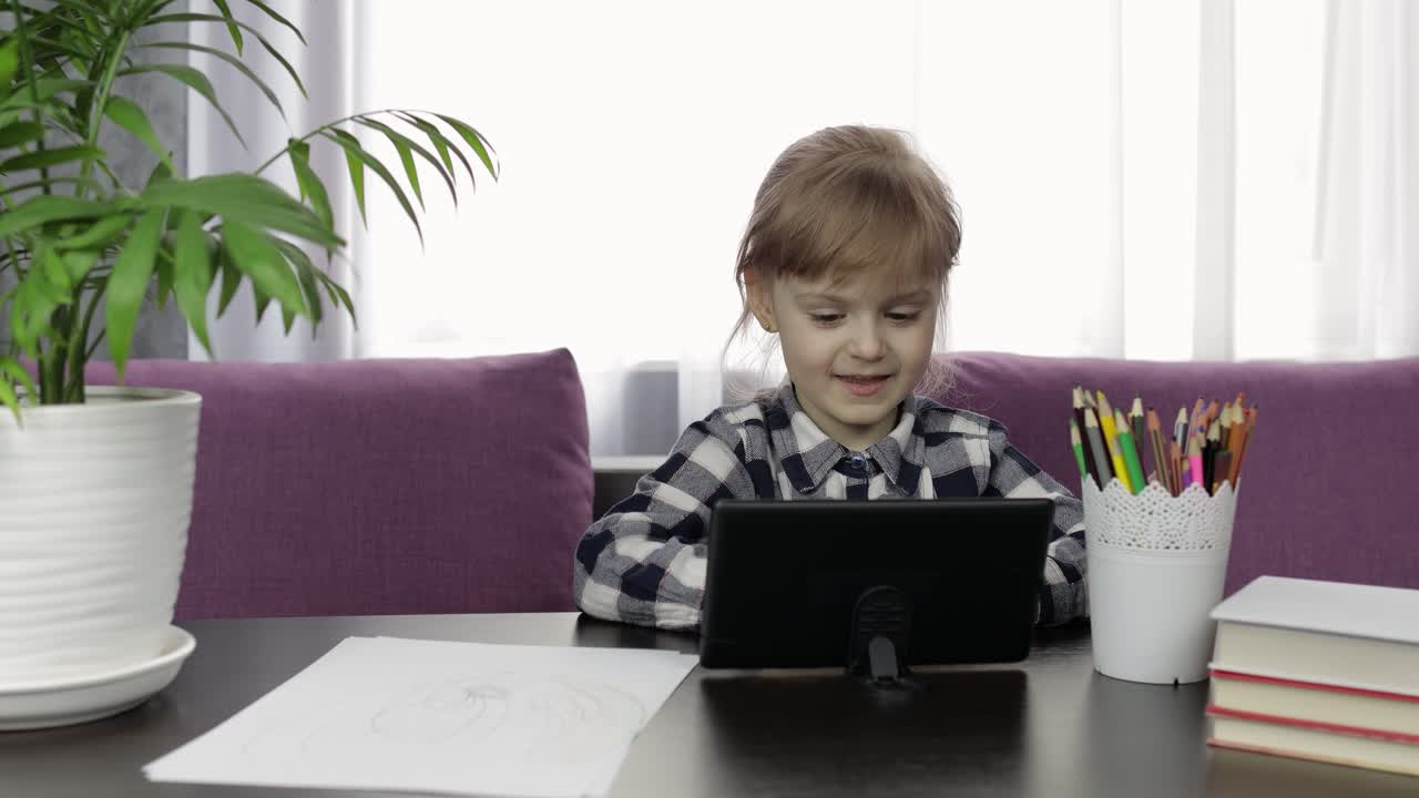 niña estudiando tareas en línea usando una tableta digital. educación a distancia