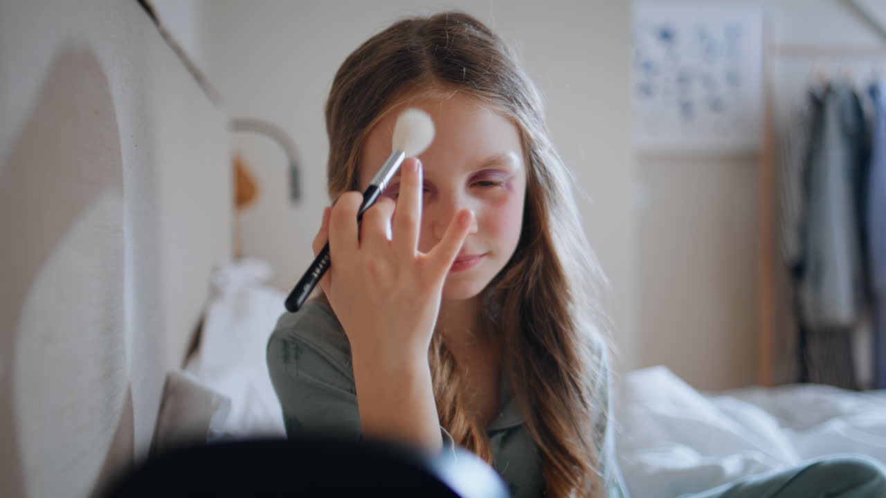 Makeup baby looking mirror holding brush closeup. Child painting face playing