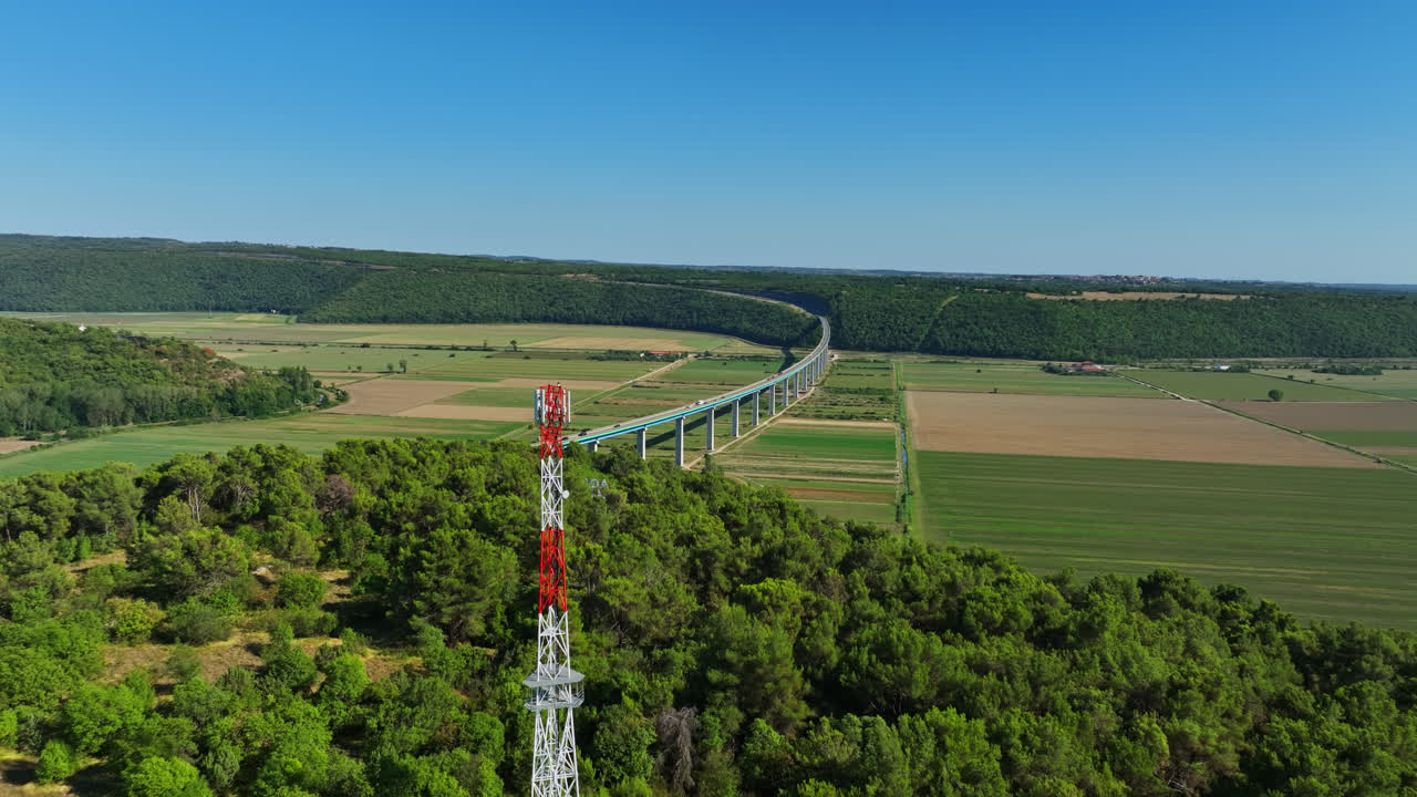 fotografía aérea de ascenso frente a una torre de radio y el puente de mirna, en croacia