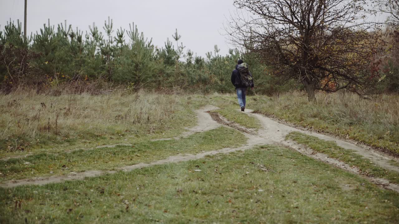 Male tourist in the forest. Young tourist with backpack walking by the forest in nature