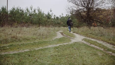 male tourist in the forest. young tourist with backpack walking by the forest in nature