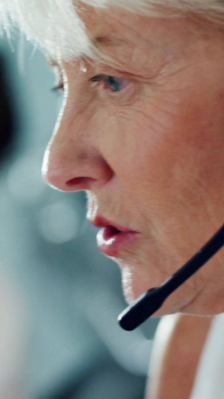 Rappresentante Anziana del Servizio Clienti al Telefono con Cuffie in Ufficio