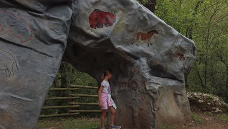 strange markings and drawing on large stones draw the attention of girl