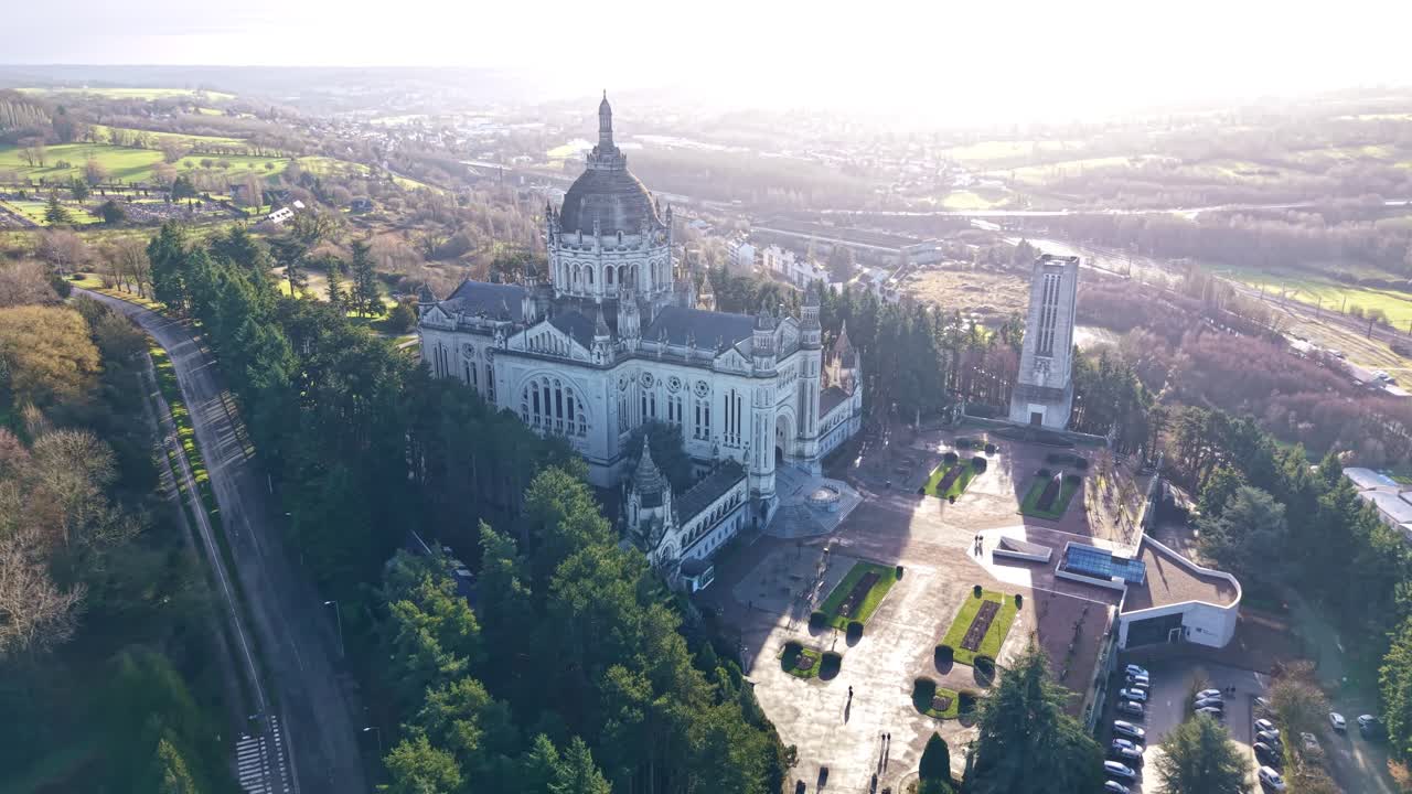 Beautiful distant drone view of the minor Basilica of Sainte-Thérese of Lisieux and surrounded landscape, Lisieux, France