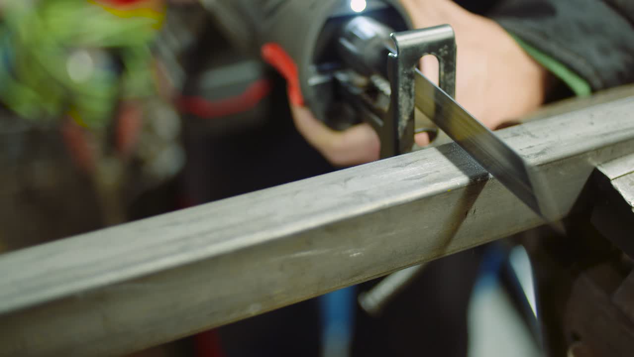 trabajador de la industria de piezas metálicas con sierra eléctrica