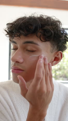 vertical video: applying moisturizer, person feeling relaxed during skincare routine at home