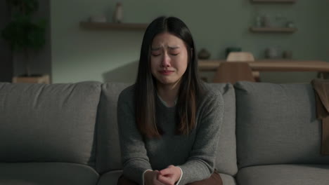 young woman crying and distressed on a couch