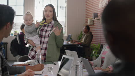 business people meeting team leader mother holding baby talking to colleagues discussing corporate project multitasking in modern office workplace