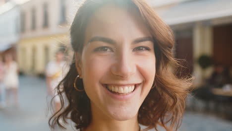 happy young woman smiling looking away dreaming, resting, good news, feel satisfied in city street