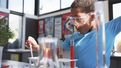 en un aula de escuela, un joven estudiante afroamericano lleva a cabo un experimento