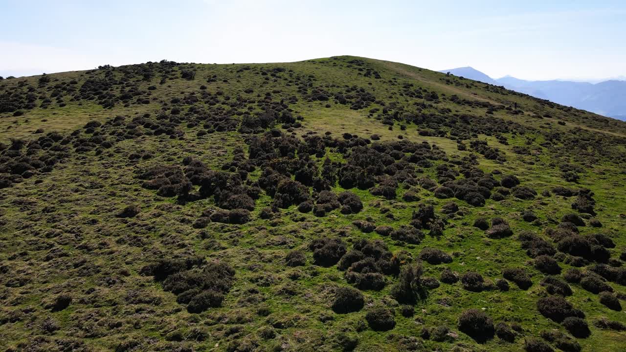 drone vuela sobre una montaña verde y exuberante en el país vasco francés de los pirineos atlánticos para revelar muchas montañas y vistas al campo detrás