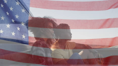 animation of american flag waving over biracial couple on beach by seaside