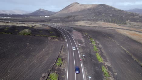 aerial shot of moving cloud's shadows, cars overtaking biker in lanzarote island