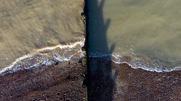 Dark sea water waves hitting the pebble beach on the Kent coast of Herne Bay in UK