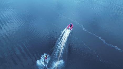 kneeboarder cutting out behind speed boat high angle aerial