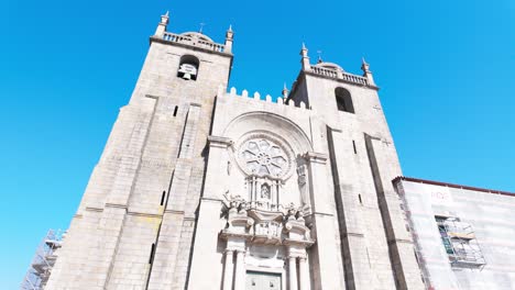 porto cathedral under a vibrant blue sky, showcasing its historical architecture from below