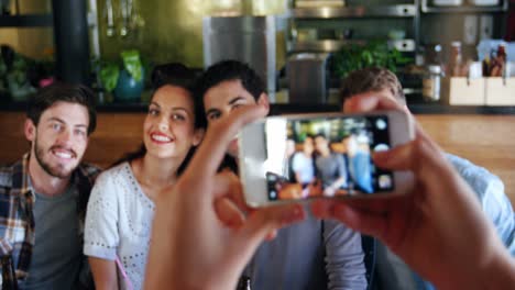 mujer haciendo clic en la foto de amigos en el teléfono móvil