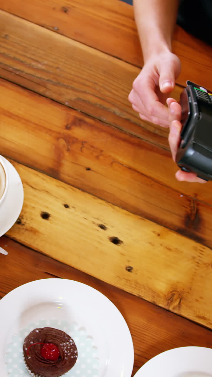 cliente que realiza un pago a través de una máquina terminal de pago en el mostrador