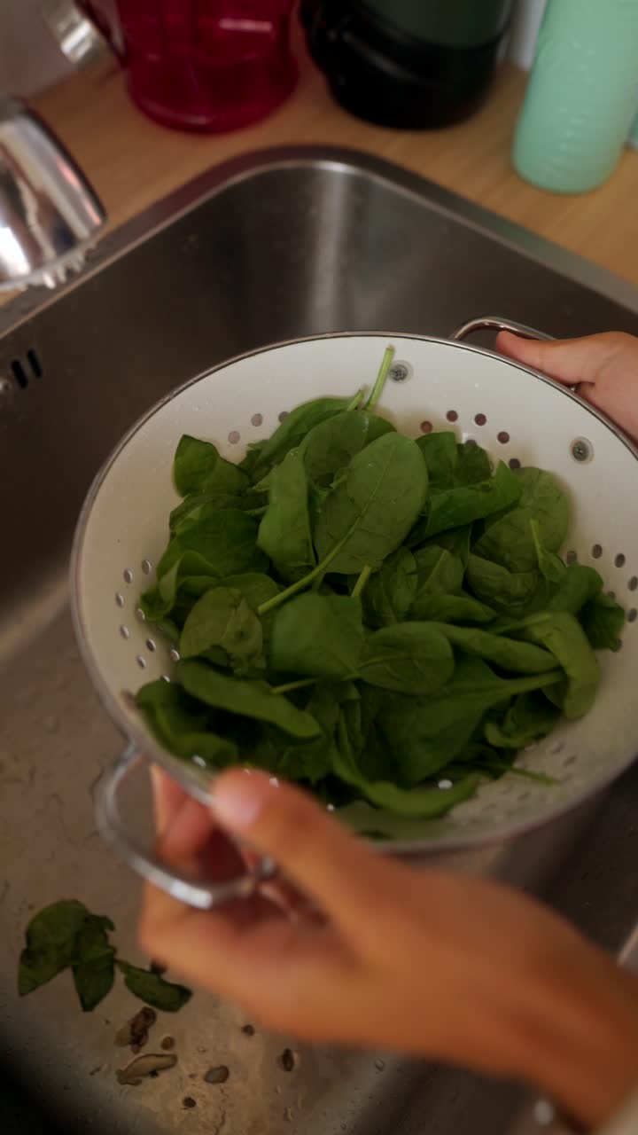 Lavare gli spinaci nel lavello della cucina