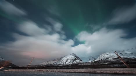 snowy fjords in tromsø under a fast-moving sky with aurora glimpses, timelapse