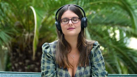 Chica-Escuchando-Música-Con-Auriculares-Con-Los-Ojos-Cerrados-En-El-Parque