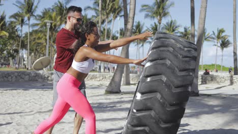 pareja deportiva entrenando con neumáticos juntos