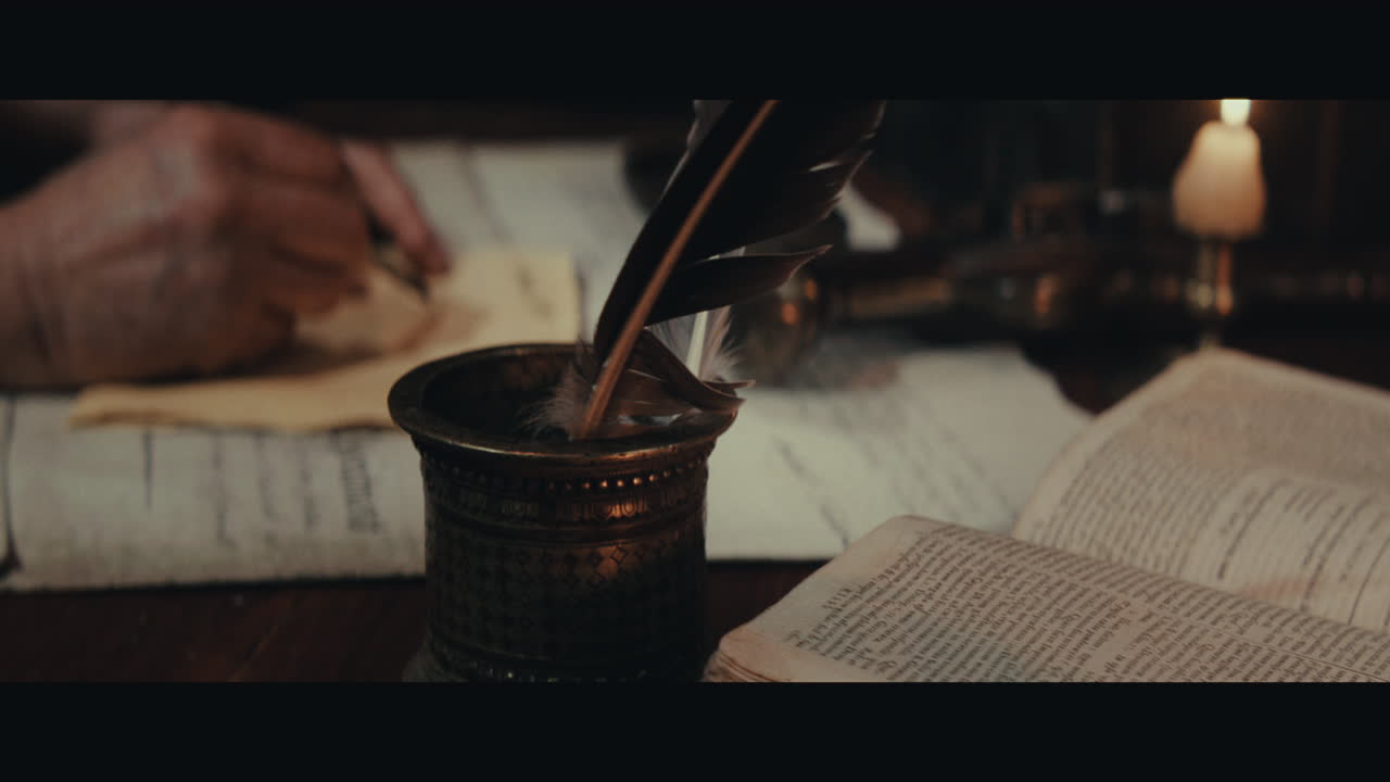 An old captain sits writes a letter inside the sailing ship cabin