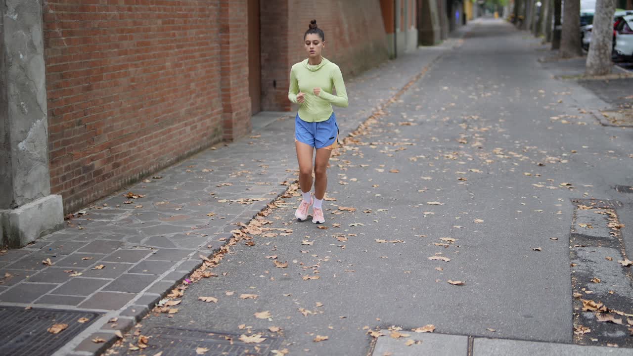 mujer corriendo por la calle de la ciudad en otoño