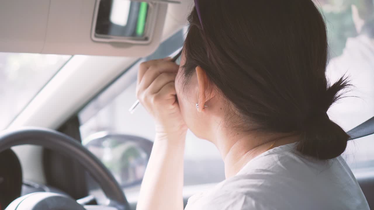 자동차를 운전하는 여자와 메이크업