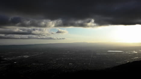 Zeitraffer-Von-Wolken,-Die-Bei-Sonnenuntergang-Dramatisch-über-Einer-Stadt-Ziehen