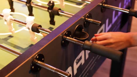 hands skillfully maneuvering foosball rods in action